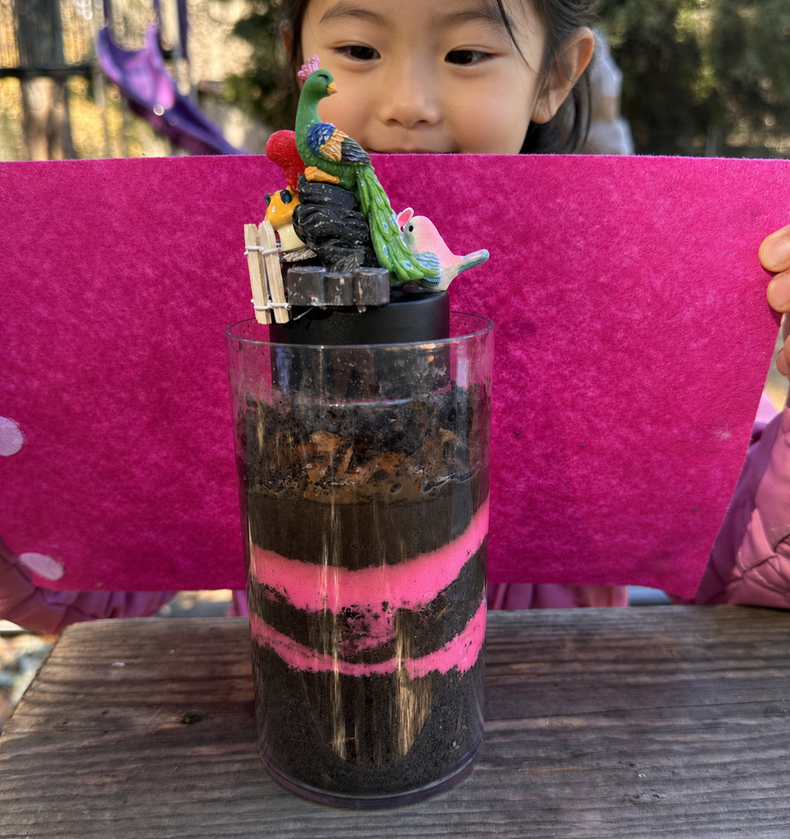 Children focusing intently as they layer soil, wood, and living organisms into their custom cricket habitats.