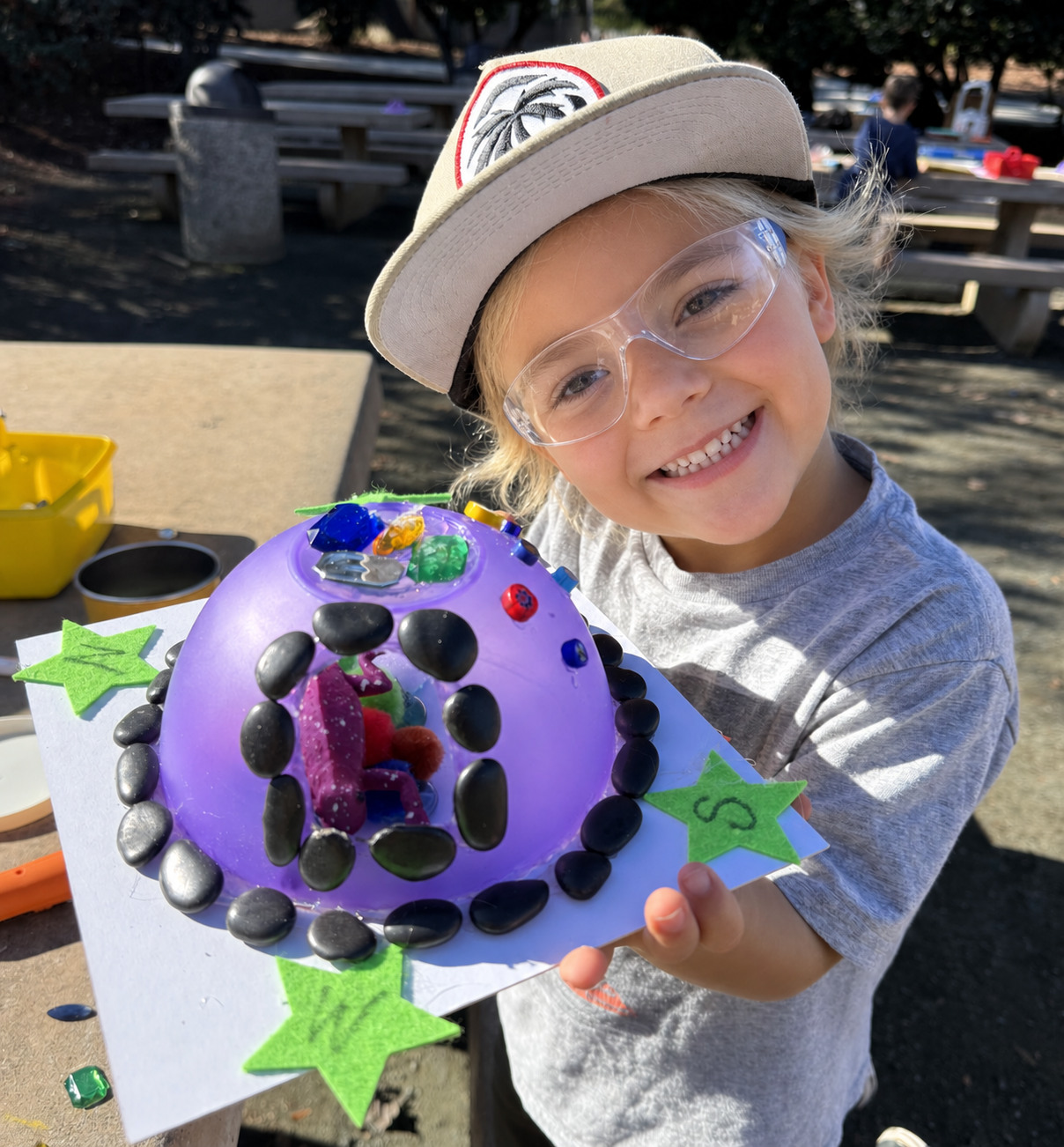 An Explorer carefully handles a high-speed rotary tool to shape a plastic sanctuary, demonstrating intense focus and fine motor control.
