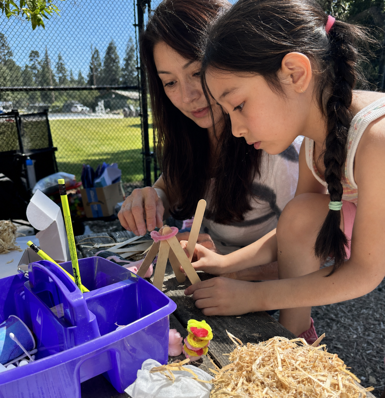 Children painting giant cardboard set houses outdoors