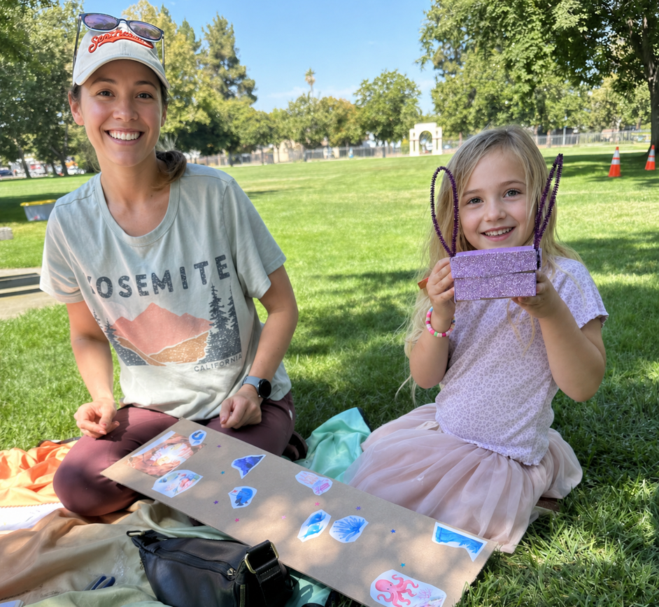 Children deeply focused at a park table, wrapping and securing their delicate egg capsules with protective layers of tape and padding.
